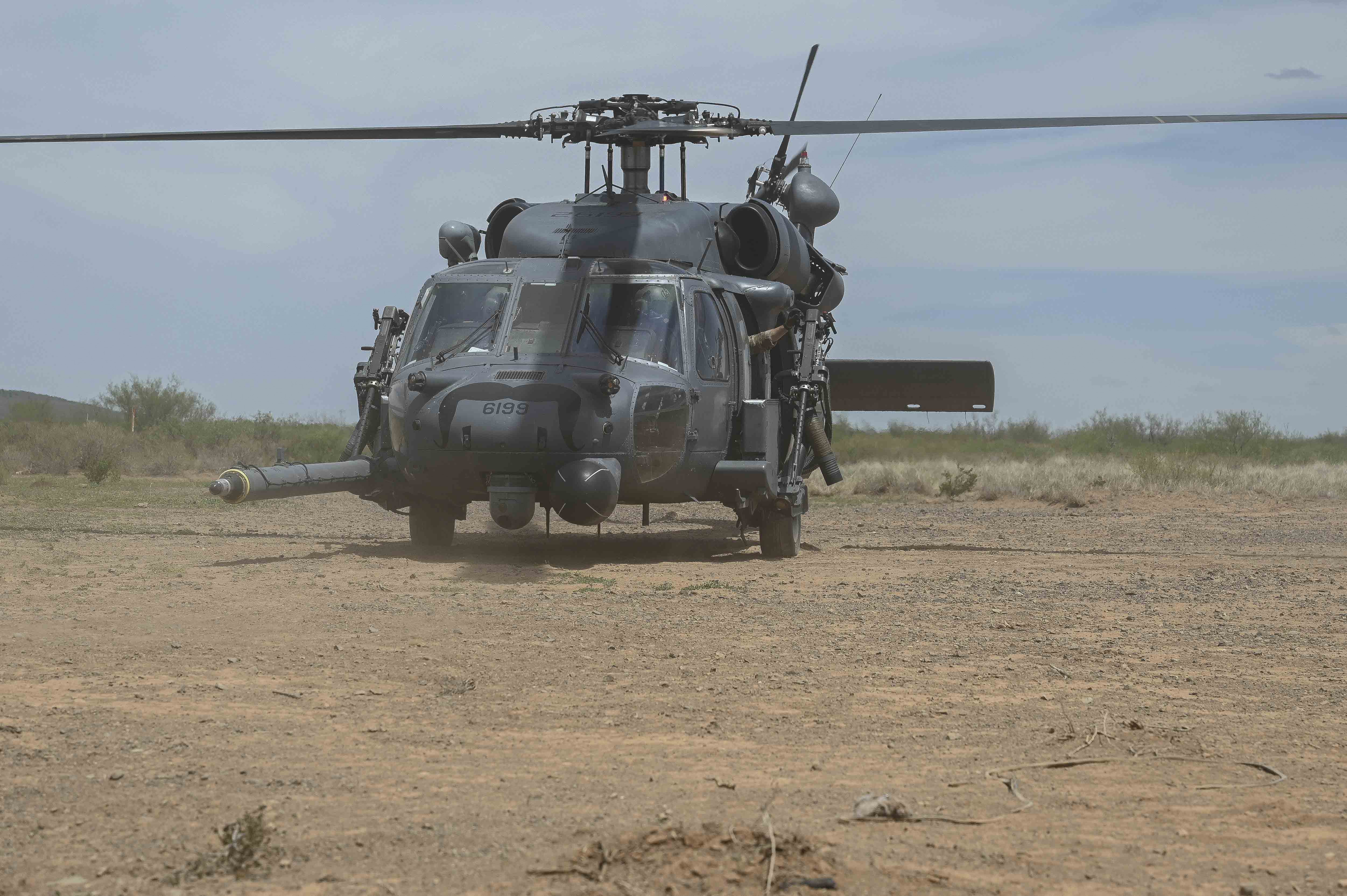 Image shows a helicopter on the ground in the desert.